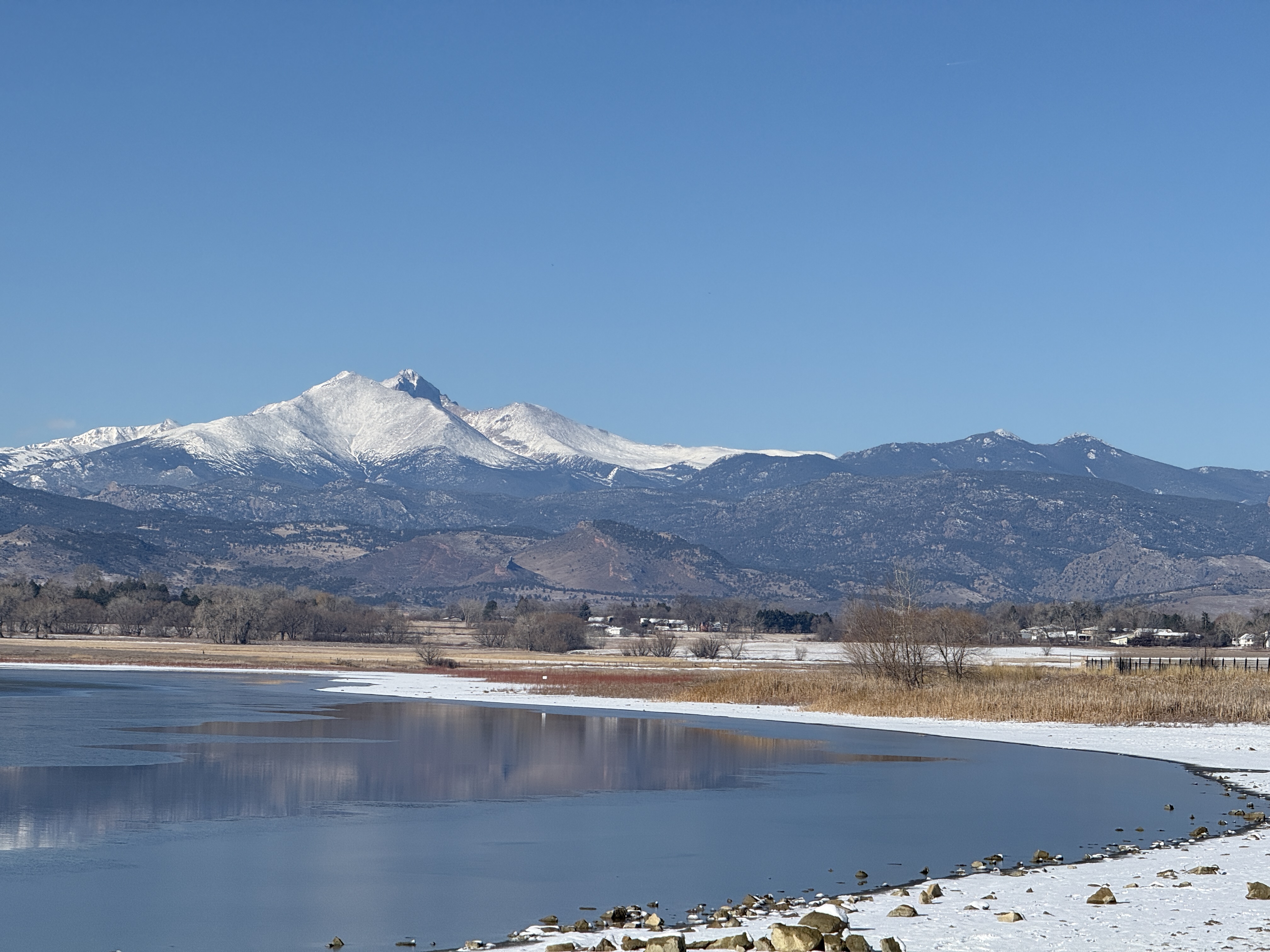 Mount Meeker and Longs Peak covered in snow over McIntosh Lake