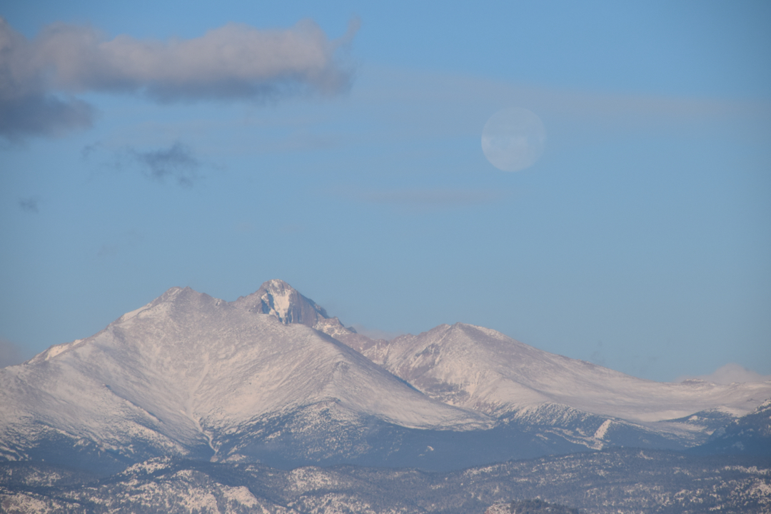 Setting moon over snowy foothills